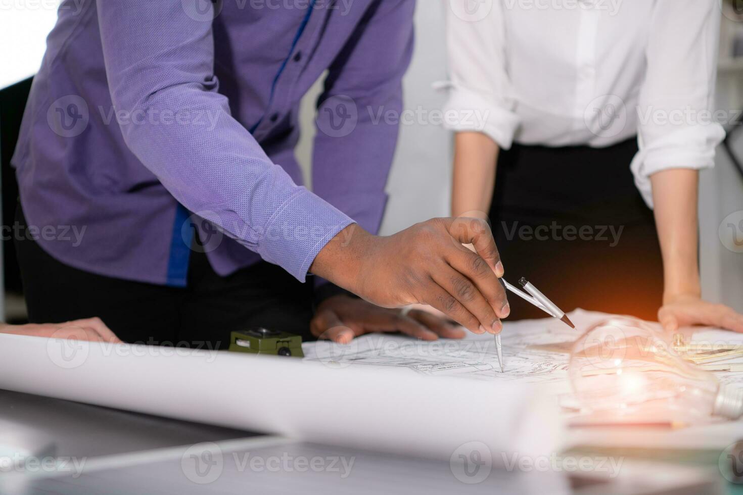 Group of architect and designer is designing a green home building that takes advantage of natural energy such as wind and sunlight. photo