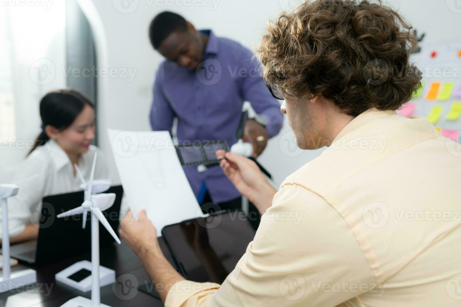 Group of multi-national team of architects and designers is meeting to brainstorm designs for wind turbines to capture wind energy and convert it into electrical energy. photo