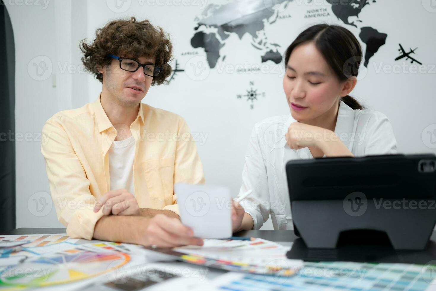 Multiethnic team of architects and designers are meeting to brainstorm design an application smartphone on a bright modern office working on a laptop. photo