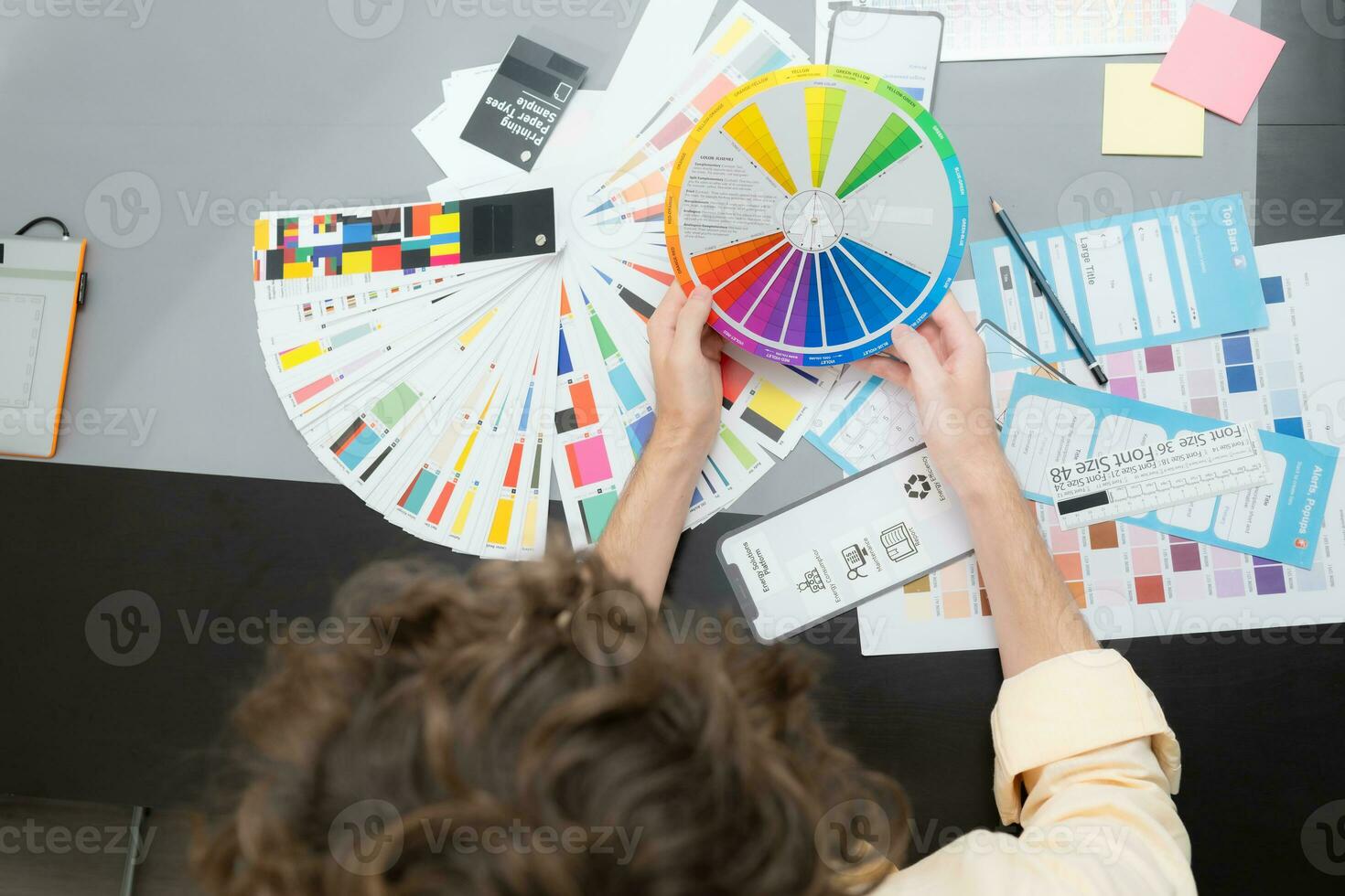 Young male architect and designer are rethinking the choice of color scheme for designing a smartphone application. photo