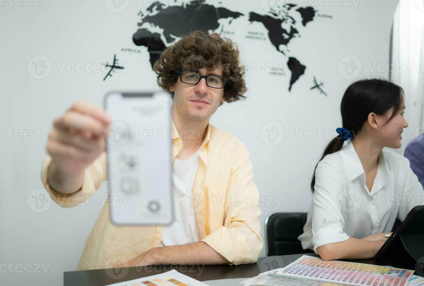 Multiethnic team of architects and designers are meeting to brainstorm design an application smartphone on a bright modern office working on a laptop. photo