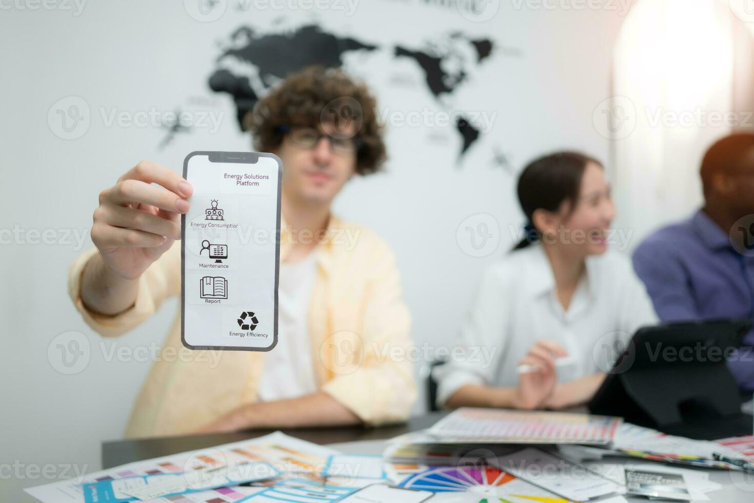 Multiethnic team of architects and designers are meeting to brainstorm design an application smartphone on a bright modern office working on a laptop. photo