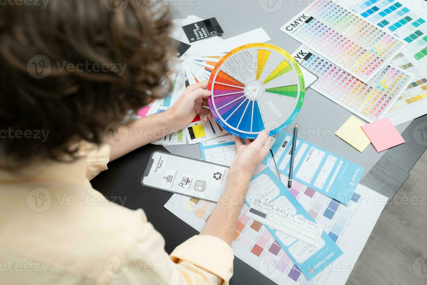 Young male architect and designer are rethinking the choice of color scheme for designing a smartphone application. photo