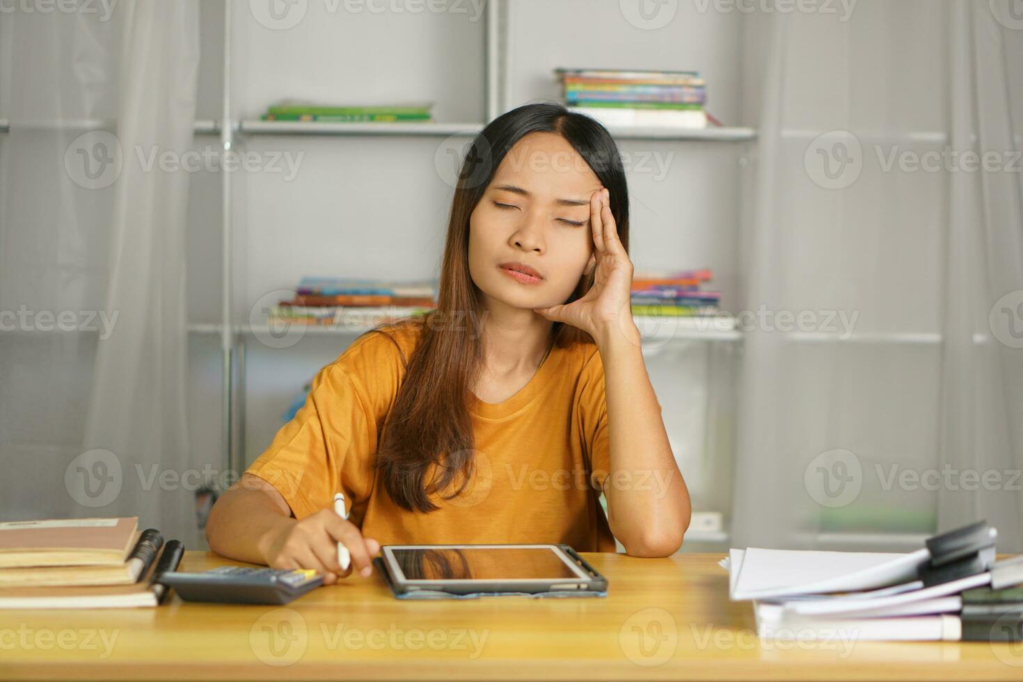 Asian woman working from home Tired of paperwork that is not completed on time photo