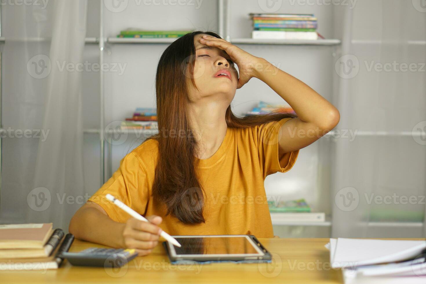 Asian woman working from home Tired of paperwork that is not completed on time photo