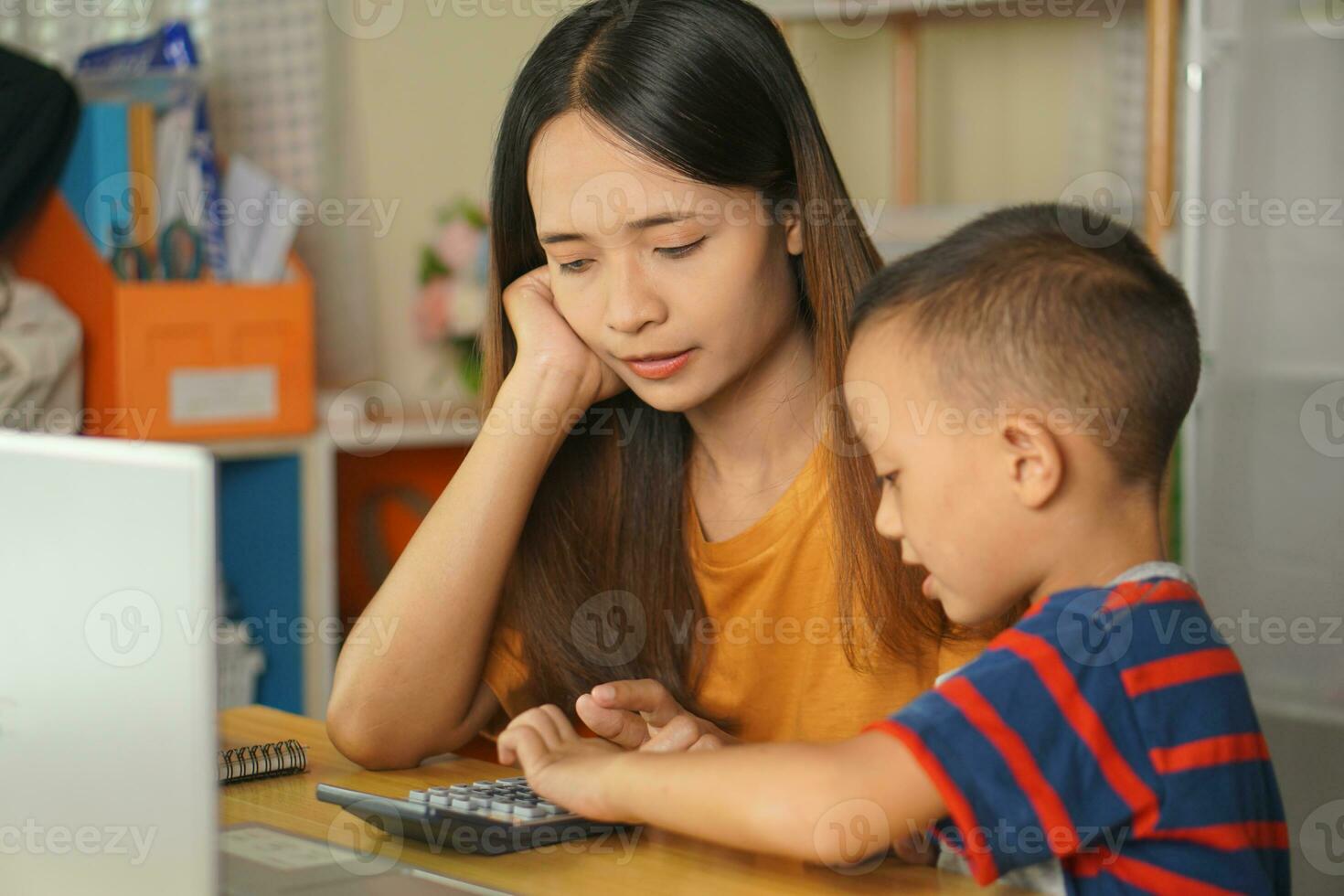 mother and son working at home Click on the calculator to see profits. photo