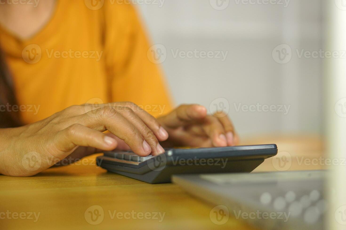 Asian women press to work from home Click on the calculator to see profits. photo