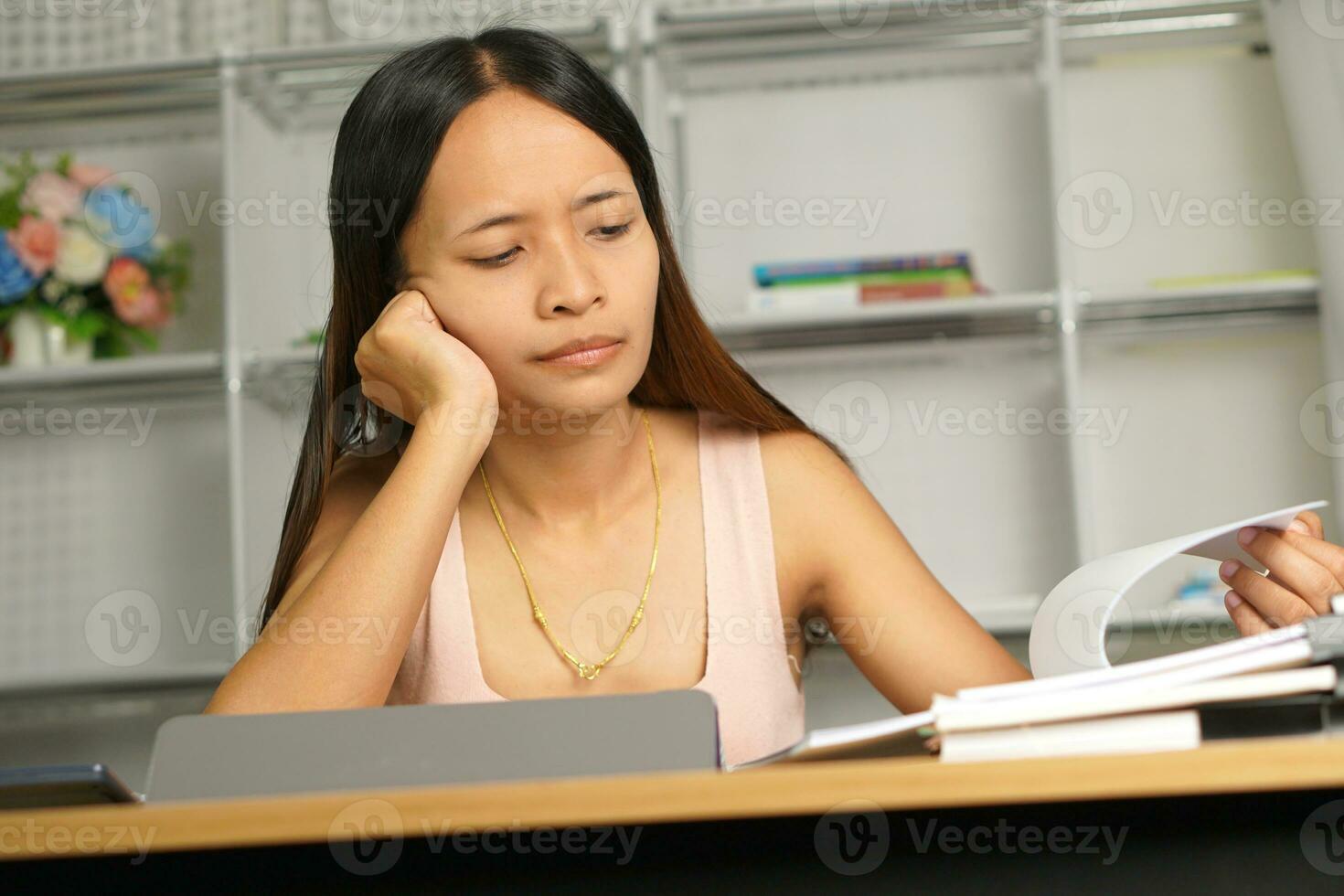 Asian woman working from home Tired of paperwork that is not completed on time photo