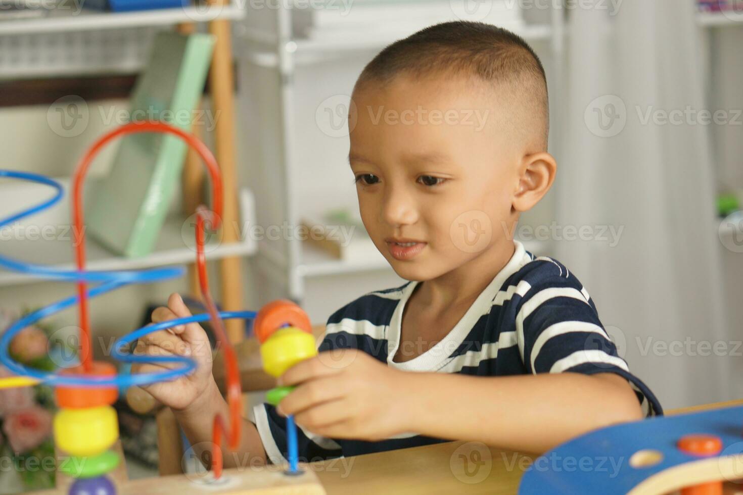 Boy playing with developmental toys on table at home photo