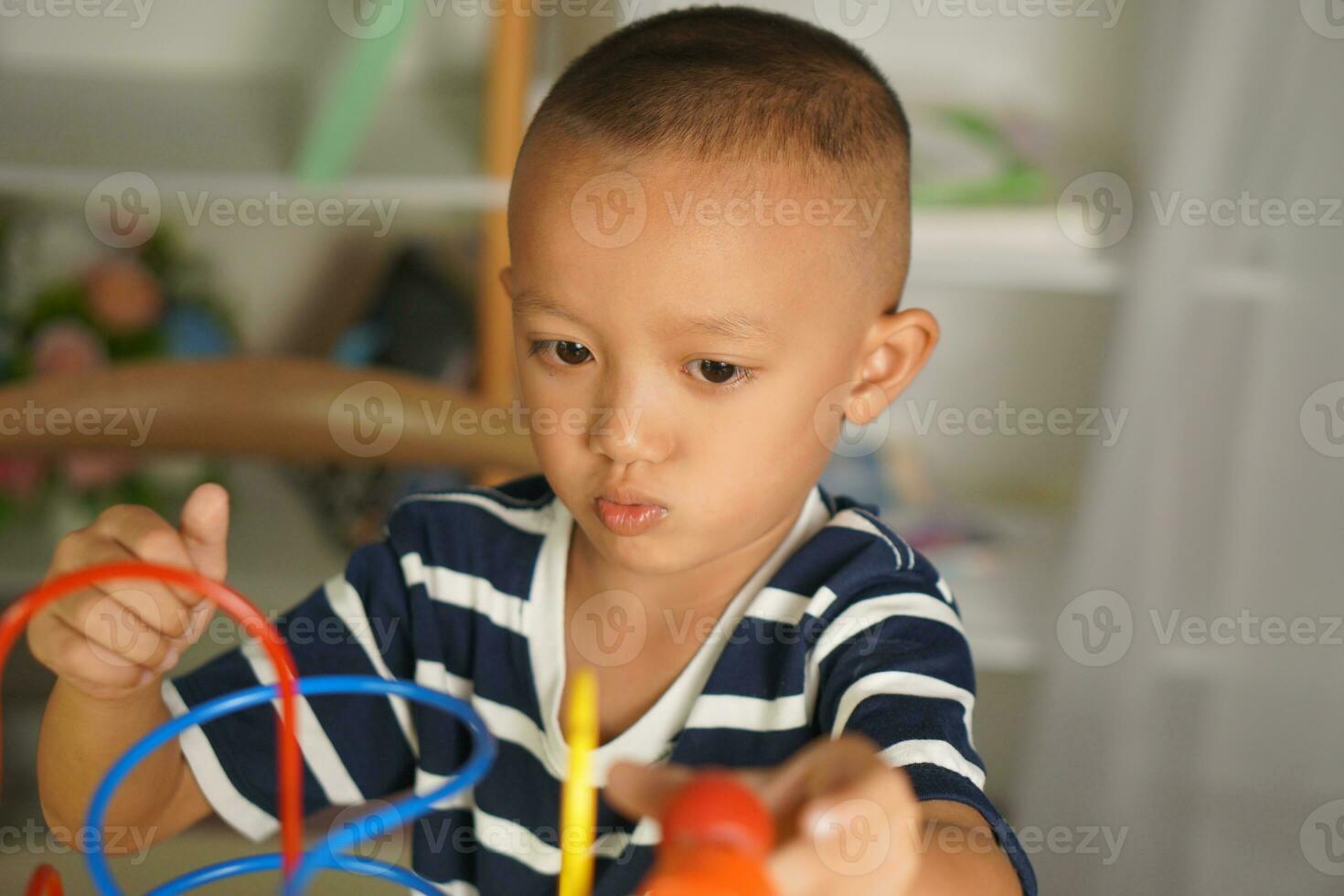Boy playing with developmental toys on table at home photo