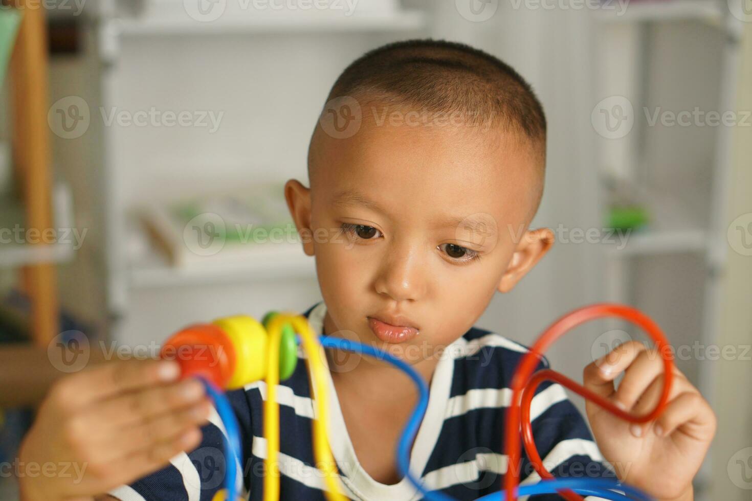 Boy playing with developmental toys on table at home photo