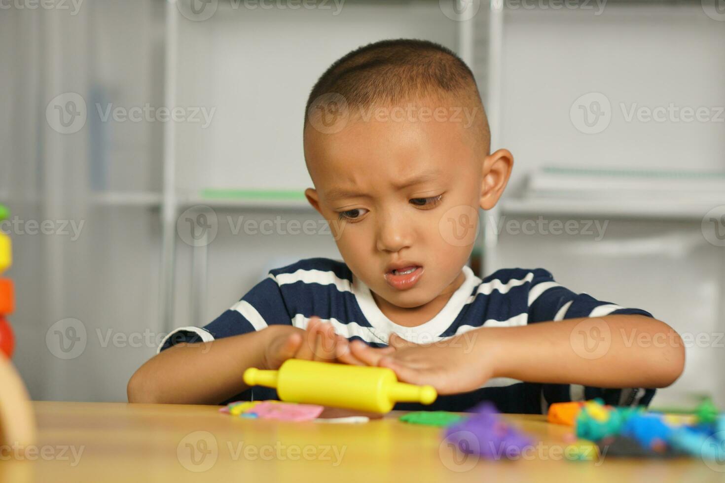 A boy kneads plasticine to make things soft. photo