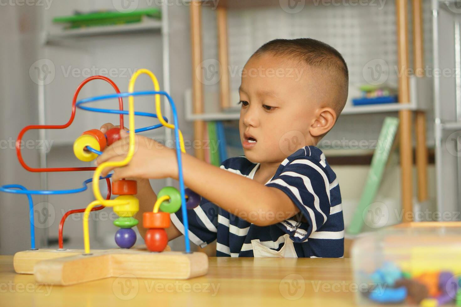 Boy playing with developmental toys on table at home photo