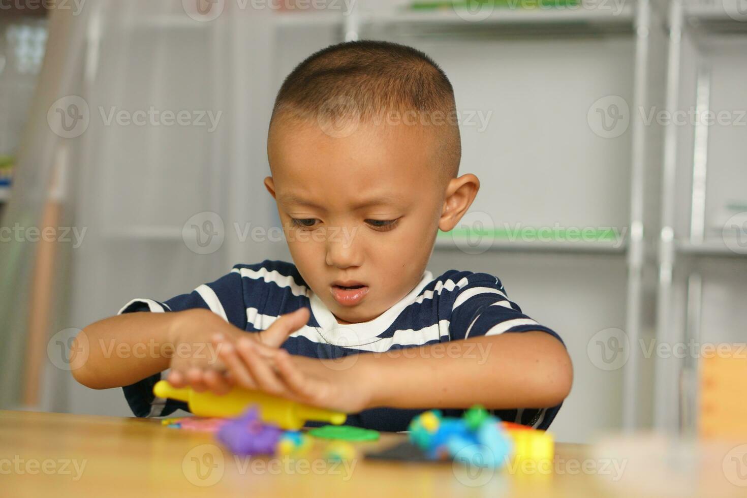 A boy kneads plasticine to make things soft. photo