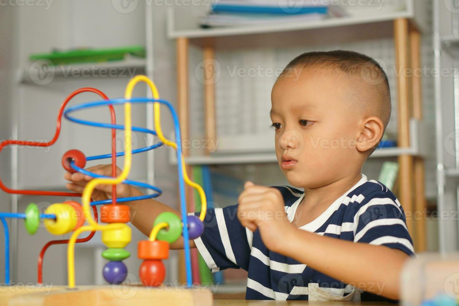 Boy playing with developmental toys on table at home photo