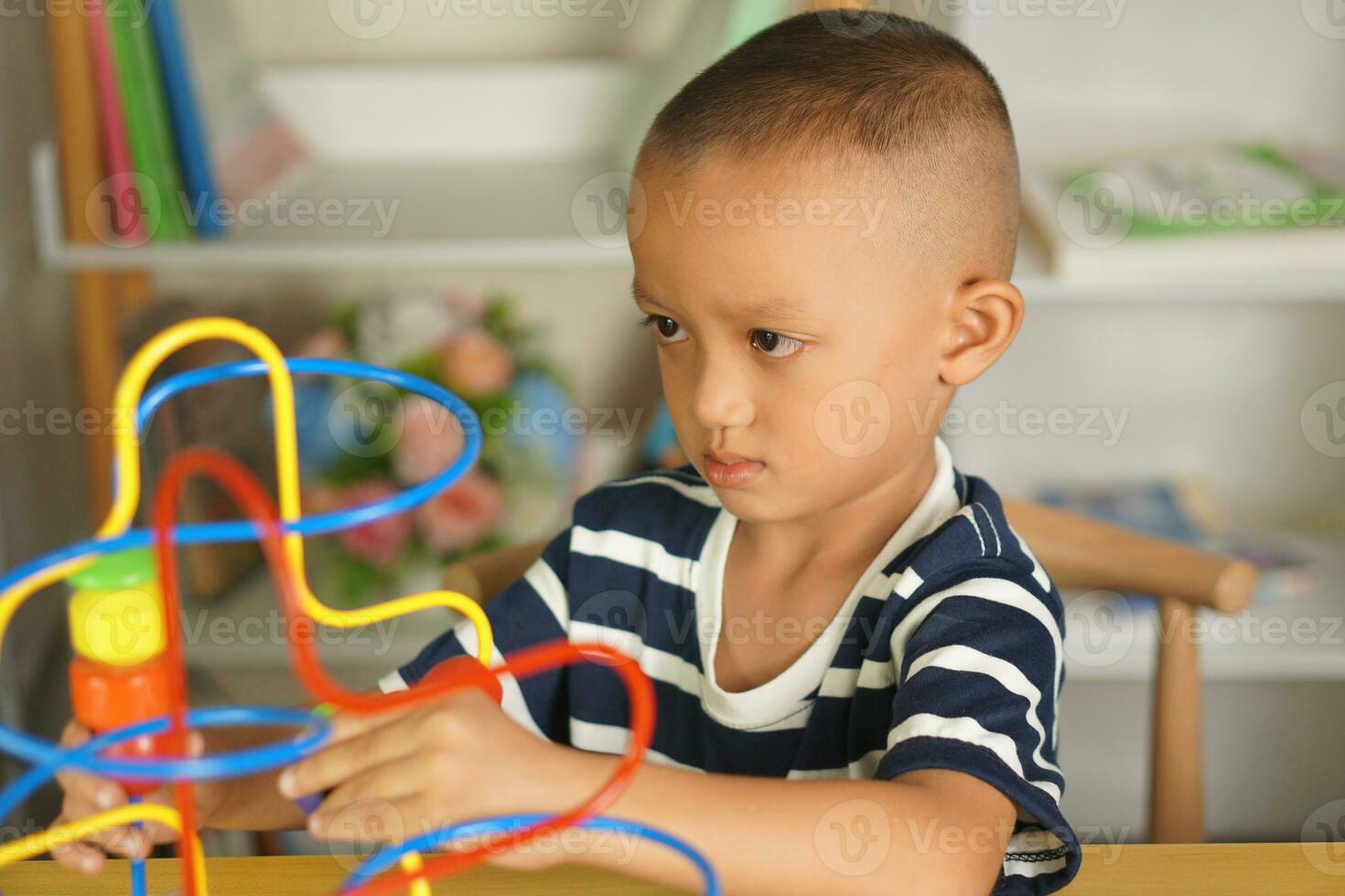 Boy playing with developmental toys on table at home photo