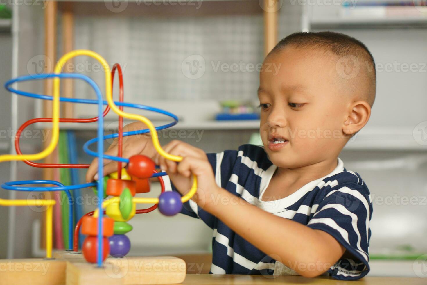Boy playing with developmental toys on table at home photo
