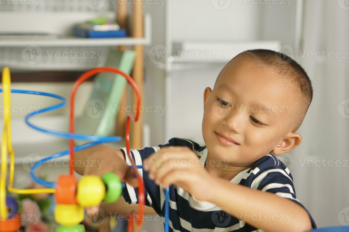 Boy playing with developmental toys on table at home photo