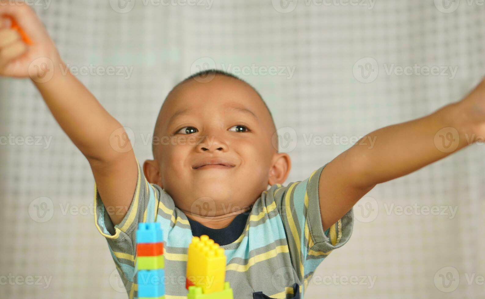 Asian boy playing with educational toys There are many beautiful colors on the table in the house. photo