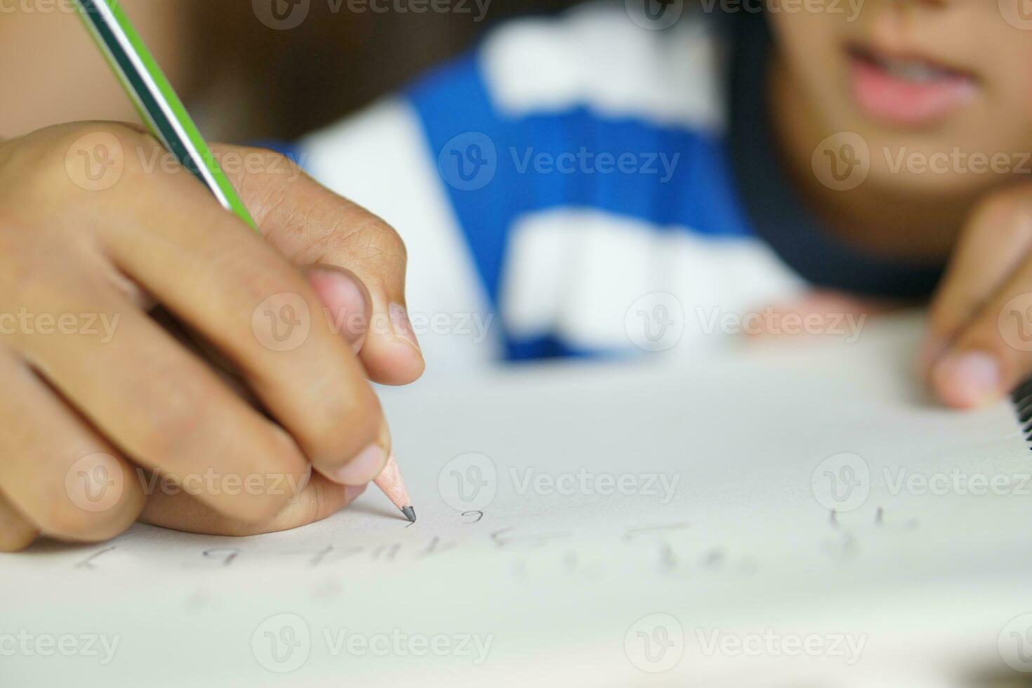 Mother holds hands with son to practice writing letters photo