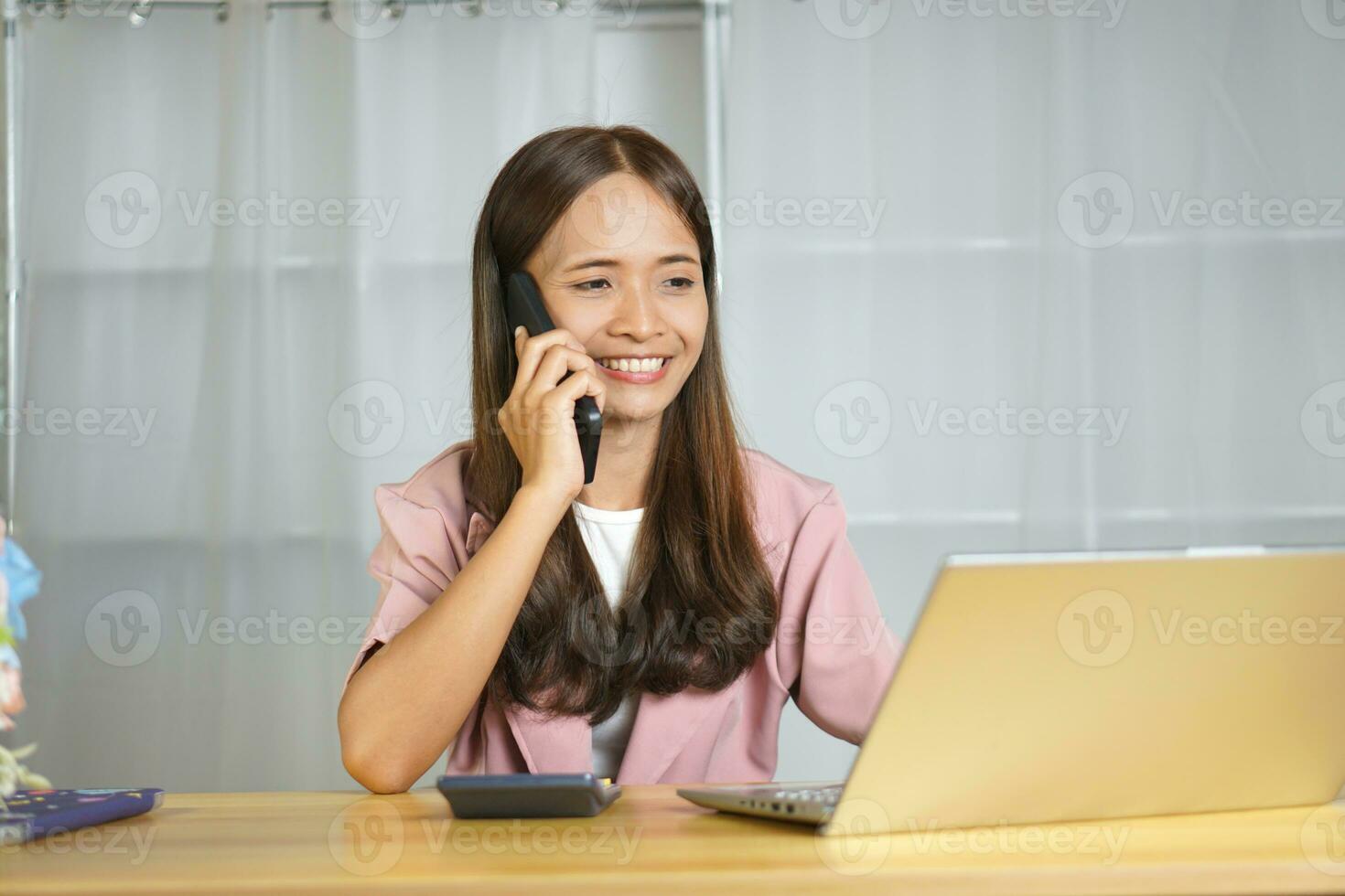 Online seller talking on the phone with customers happily from closing product deals photo