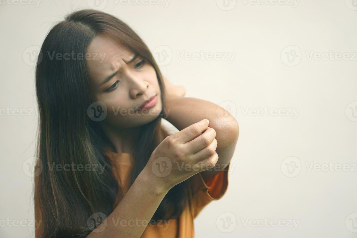 Asian woman having itchy skin on arm photo
