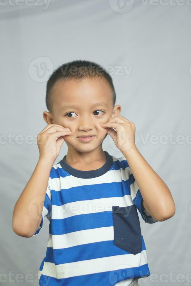 Happy smiling boy taking photo in studio