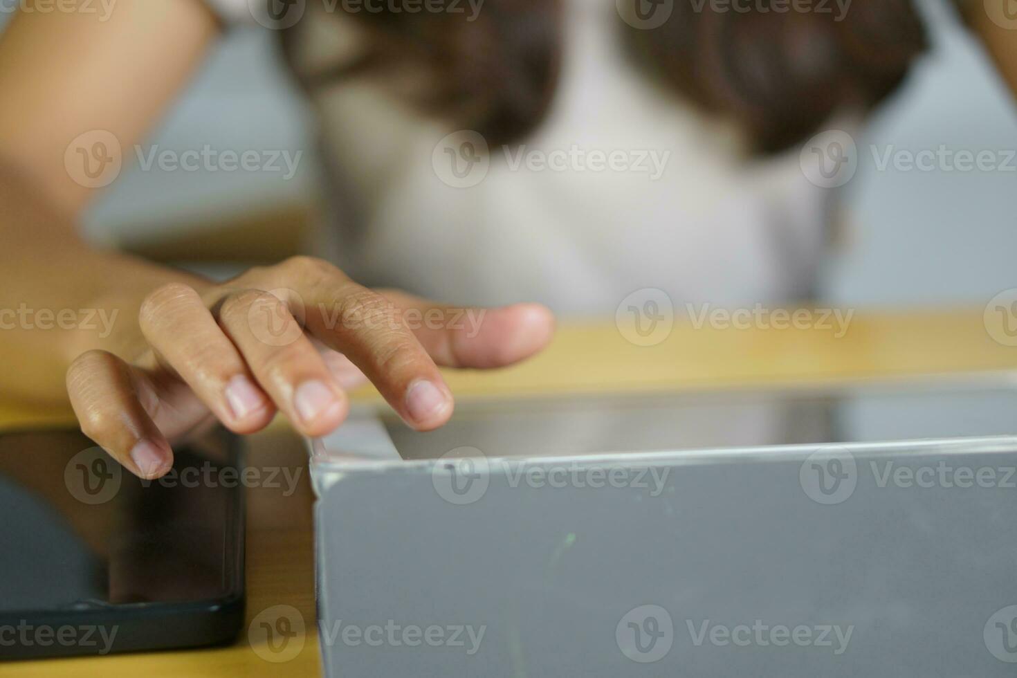 Asian woman working at home Use your hand to touch the computer screen. photo
