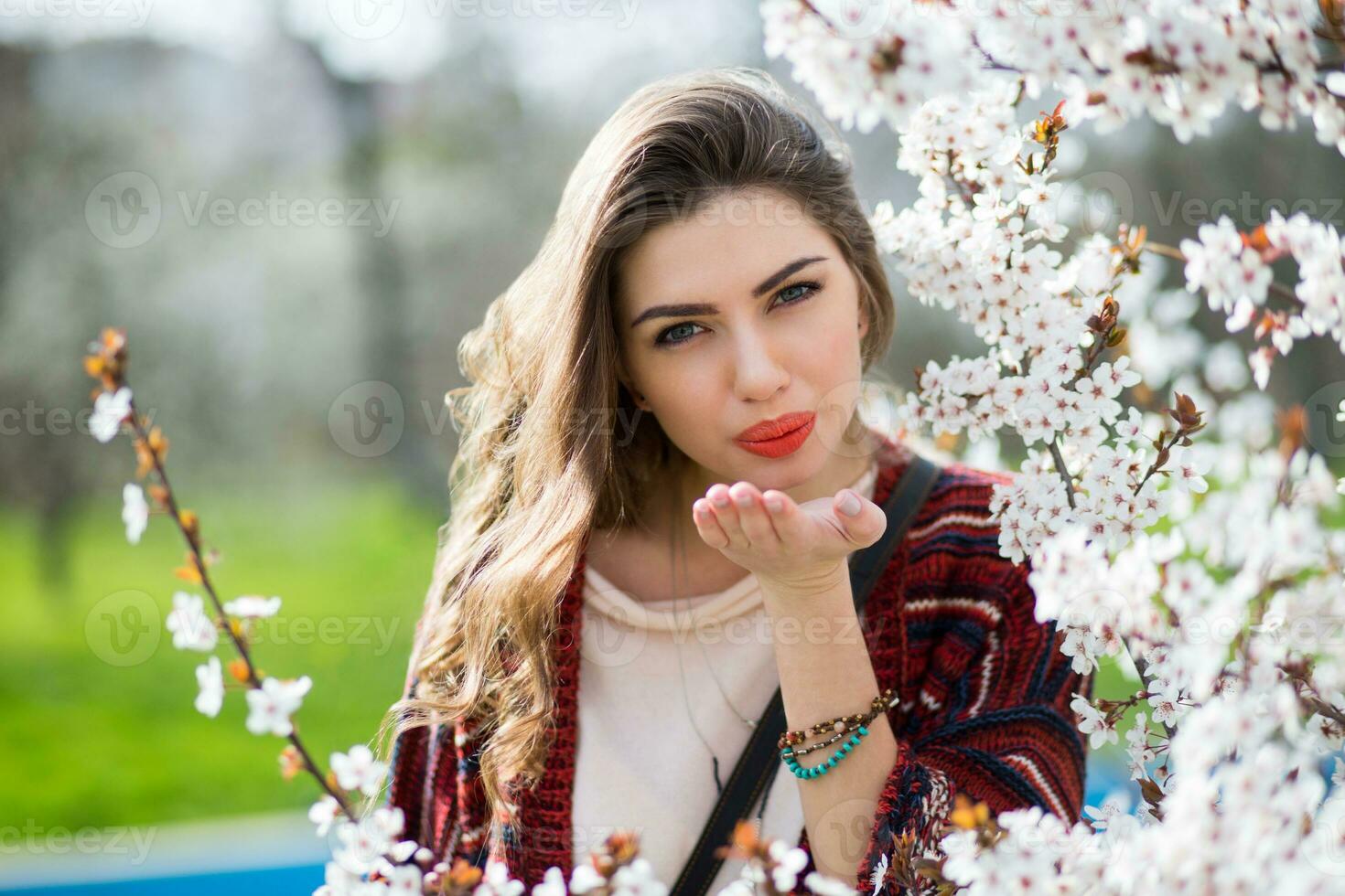 Sunny spring  portrait of happy young woman laughing and posing near flower tree. photo