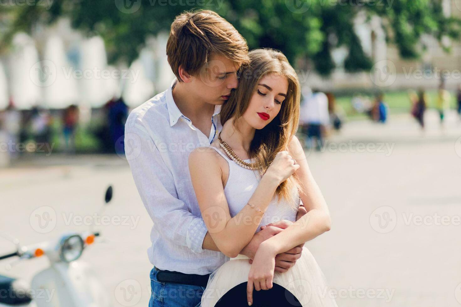 Attractive romantic couple enjoying walk together in old European city . Soft tone photo. Retro whit scooter on background. photo