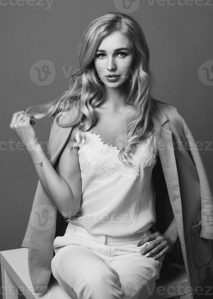 Seductive blonde woman posing in studio. Fashion portrait of elegant  model in pastel  casual  spring outfit. photo