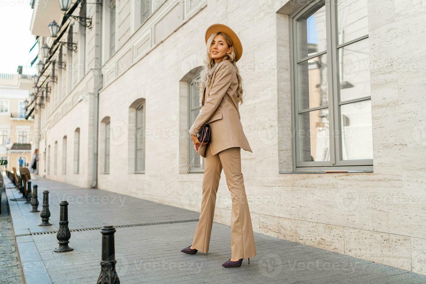 Fashion photo of gorgeous beutiful blond model posing in trendy leather  jacket and pants outdoor. Full lengt.