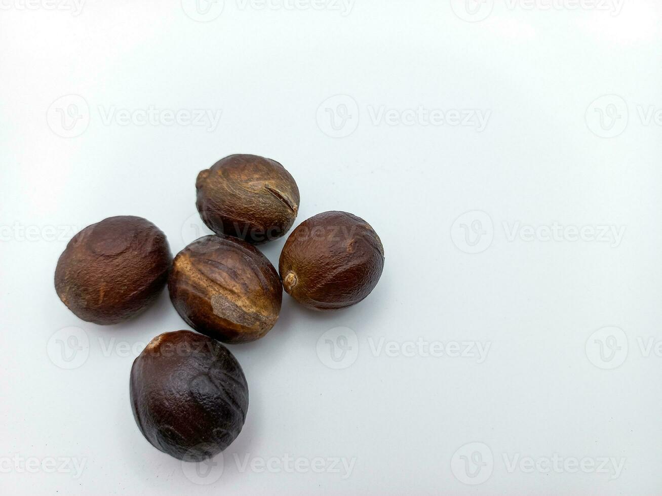 Five Whole Nutmeg isolated On White Background. Left Corner Position With Negative Space photo