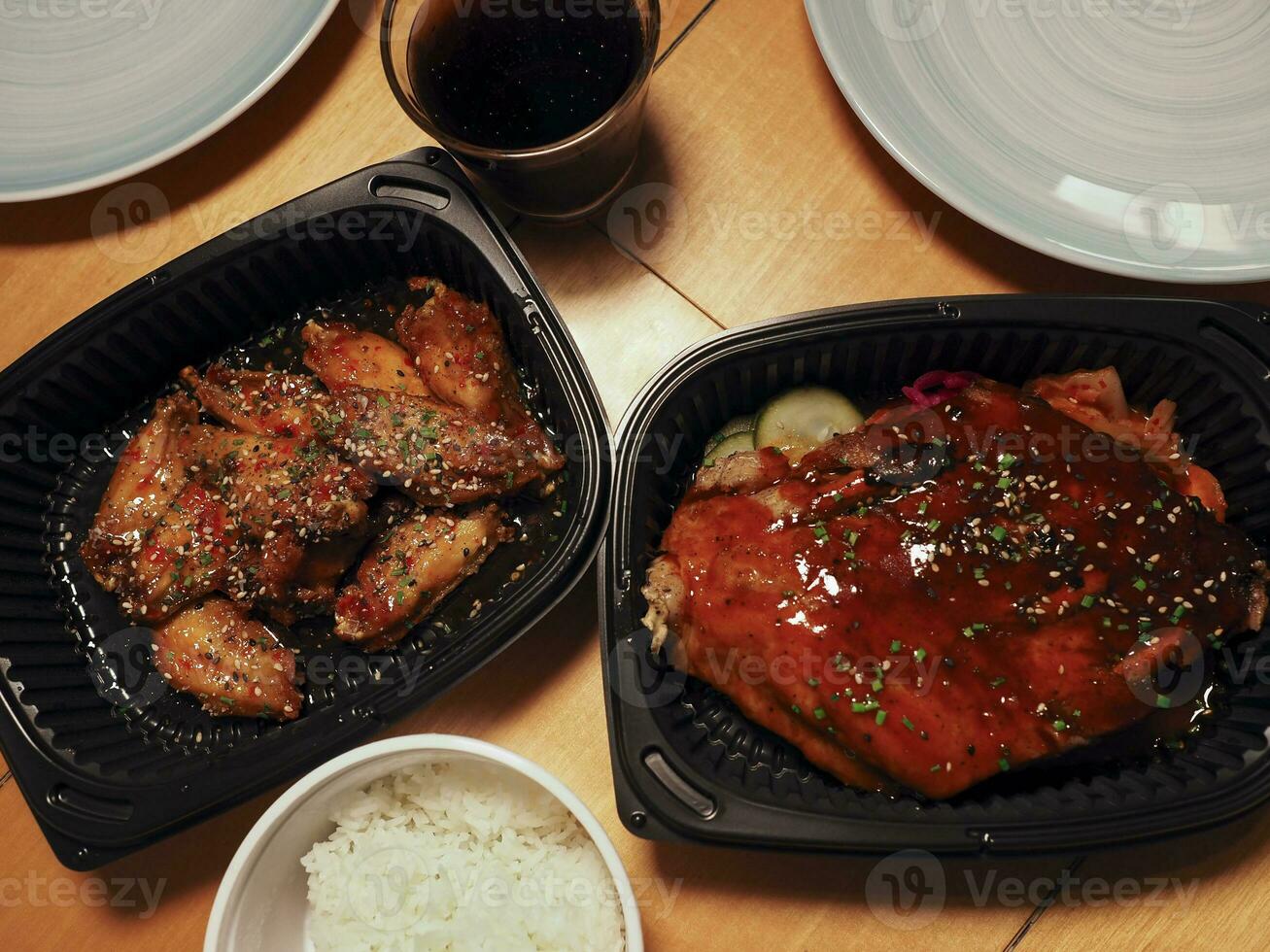 coreano Cerdo costillas con pepinillos, frito pollo alas y arroz. asiático calle alimento. foto
