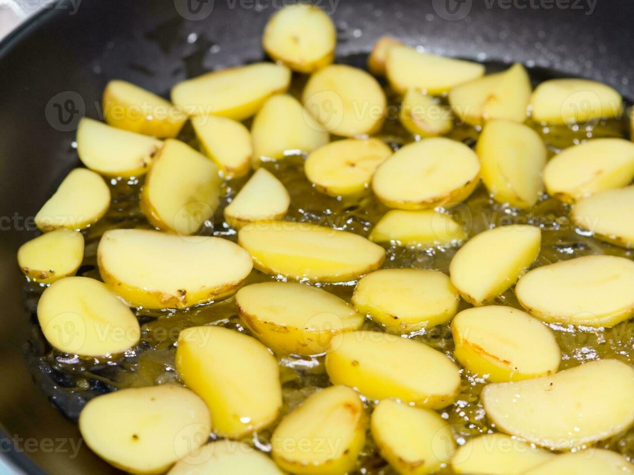 fried potatoes with oil in frying pan photo