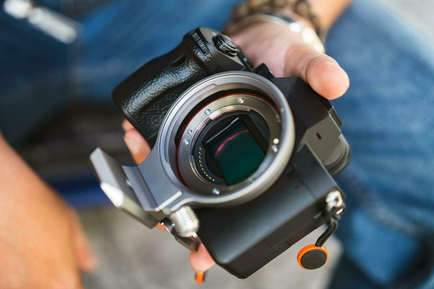 Close up of man hand hold digital camera full frame sensor and lens mount. photo