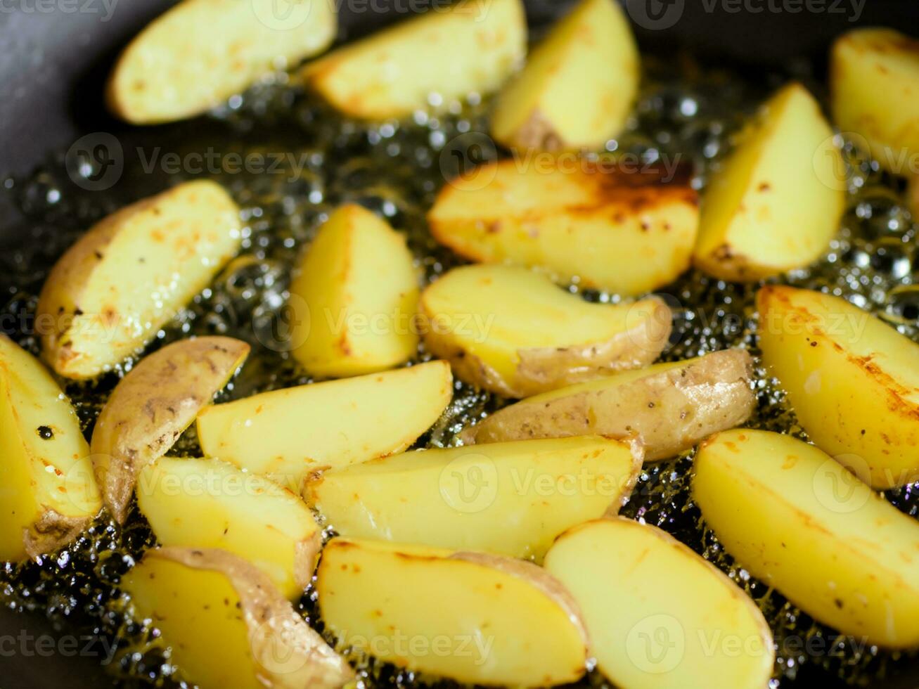 fried potatoes with oil in frying pan photo
