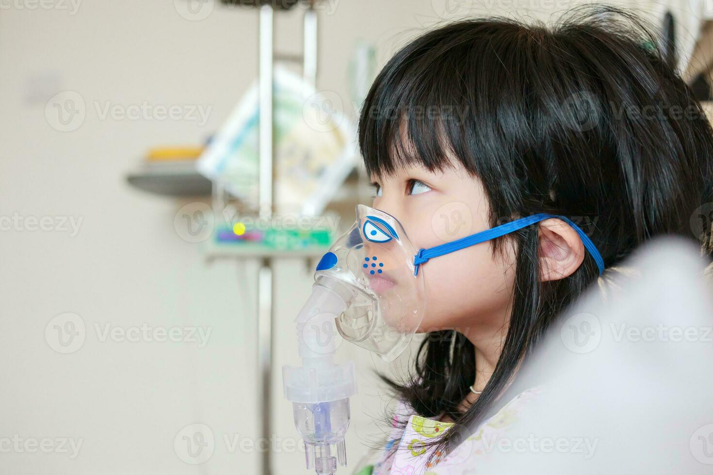 Sick little asian girl inhalation with nebulizer for respiratory treatment photo