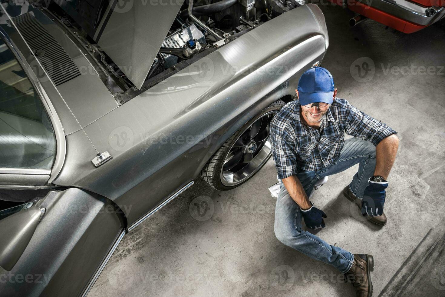 Smiling Caucasian Car Mechanic and His Workshop photo