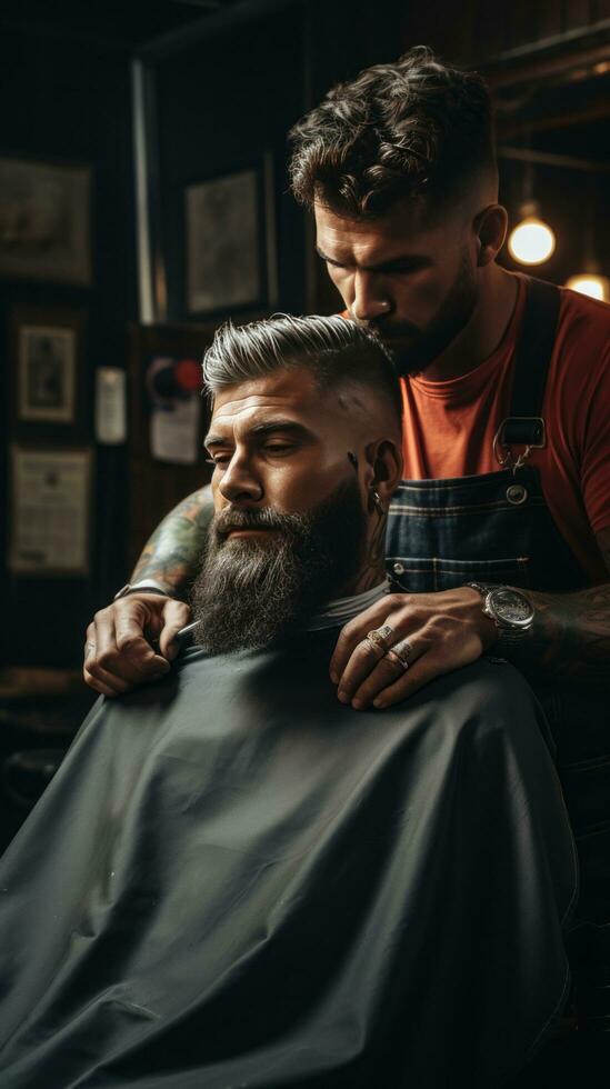 A barber trimming a man's beard with clippers photo