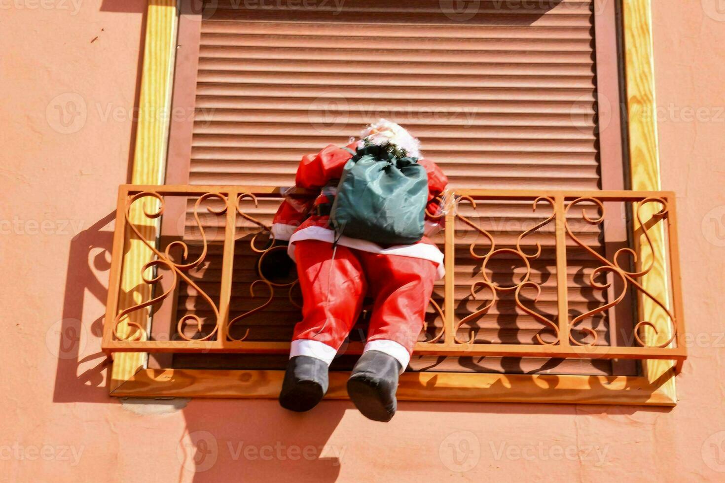 a santa claus statue hanging from a balcony photo