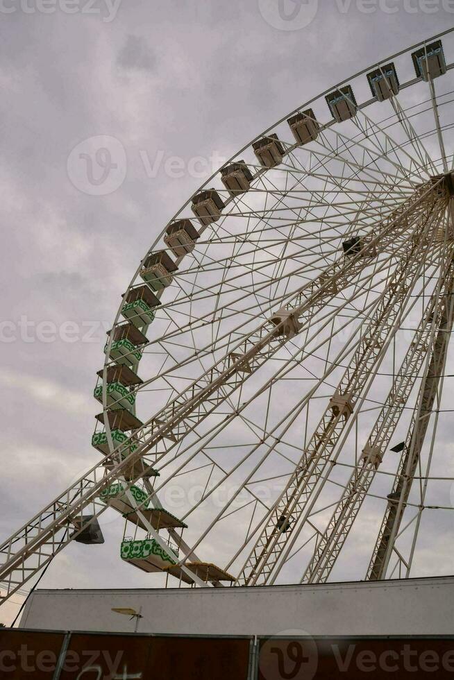 un ferris rueda es mostrado en contra un nublado cielo foto