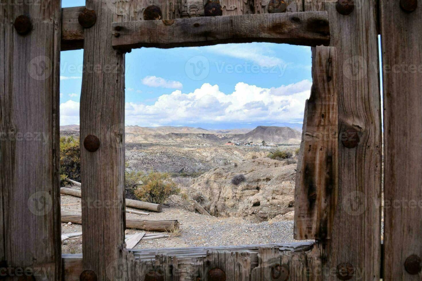 a view through a window of a wooden fence photo