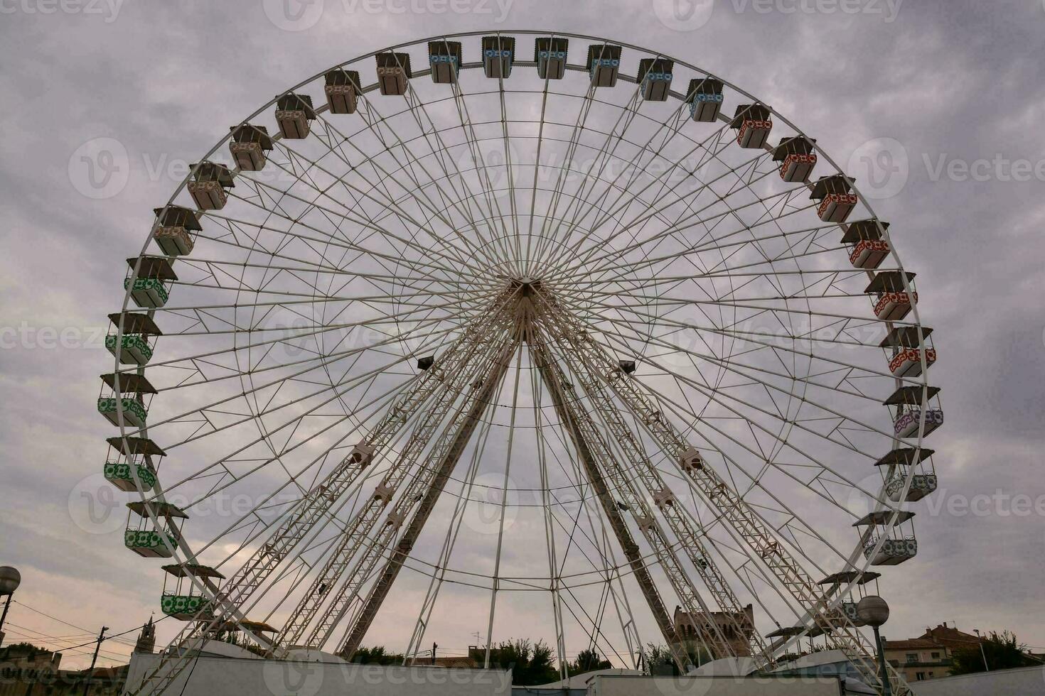 a ferris wheel is shown in front of a cloudy sky photo