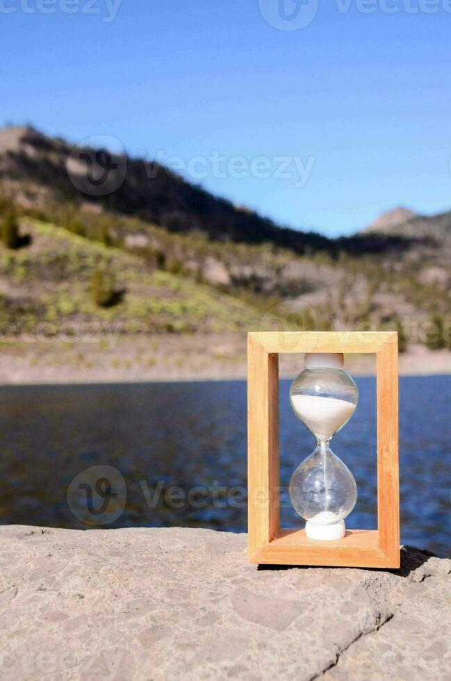 An hourglass on a rock photo