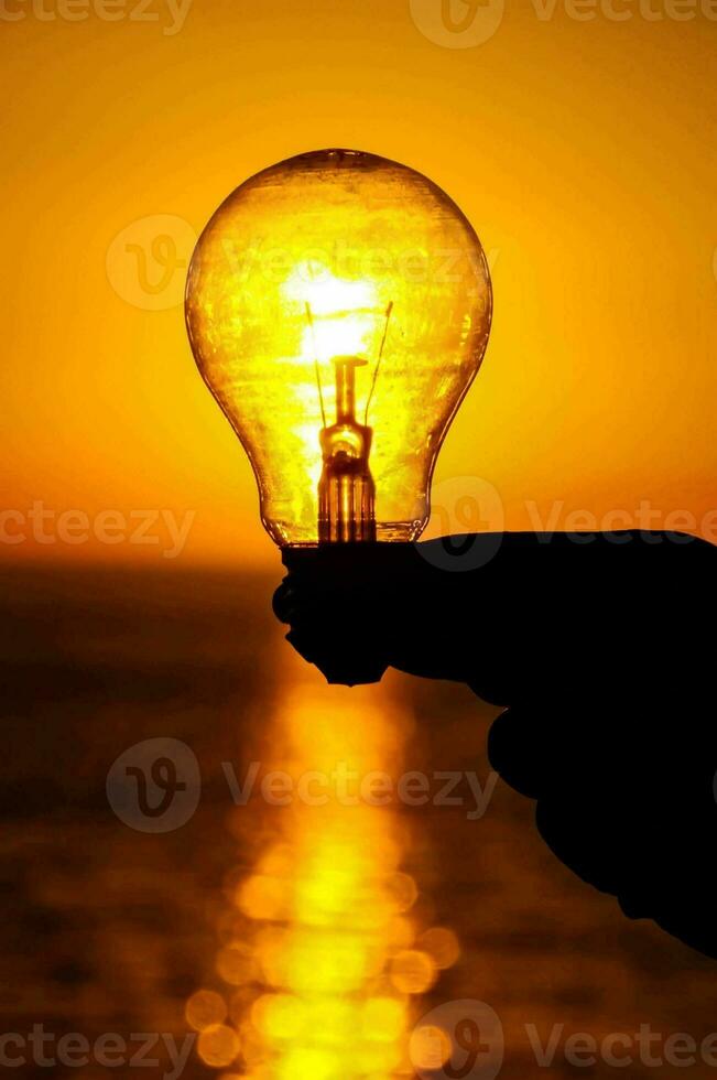 Hand holding a lightbulb photo