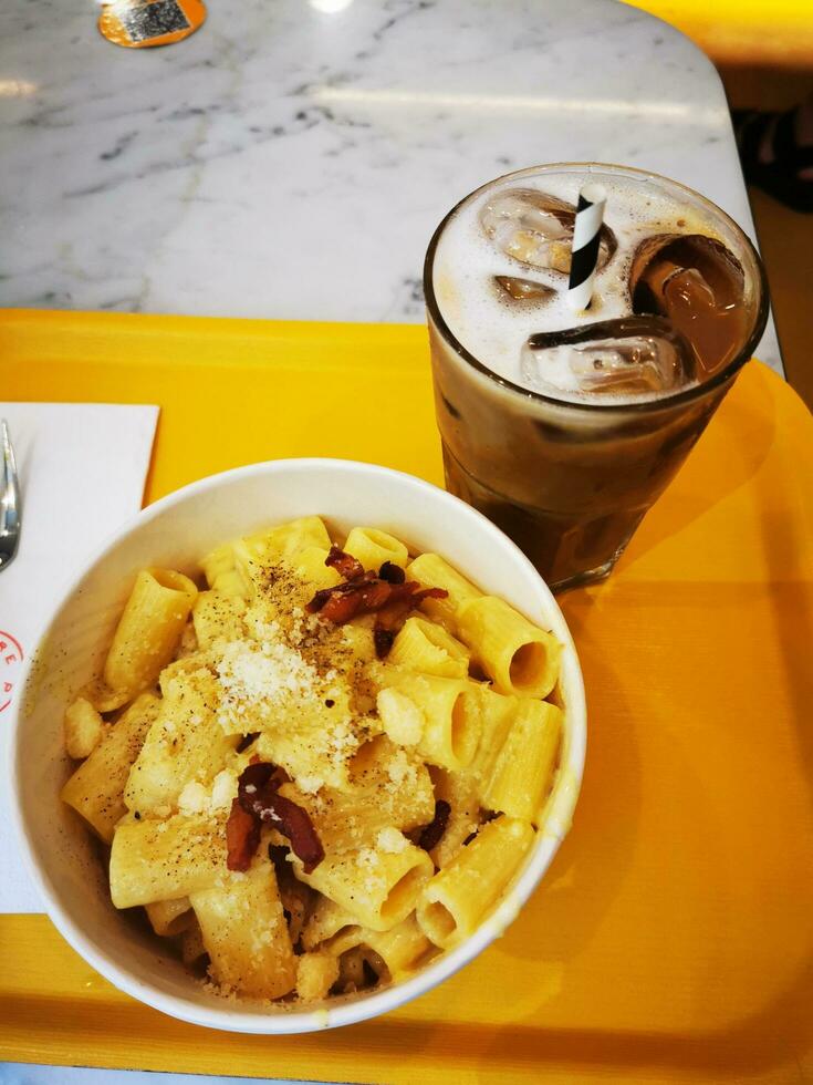 Photo of a delicious bowl of macaroni and cheese paired with a refreshing drink