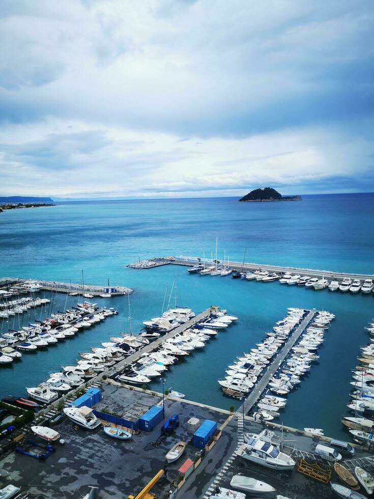 Photo of a busy marina with boats under a dramatic cloudy sky