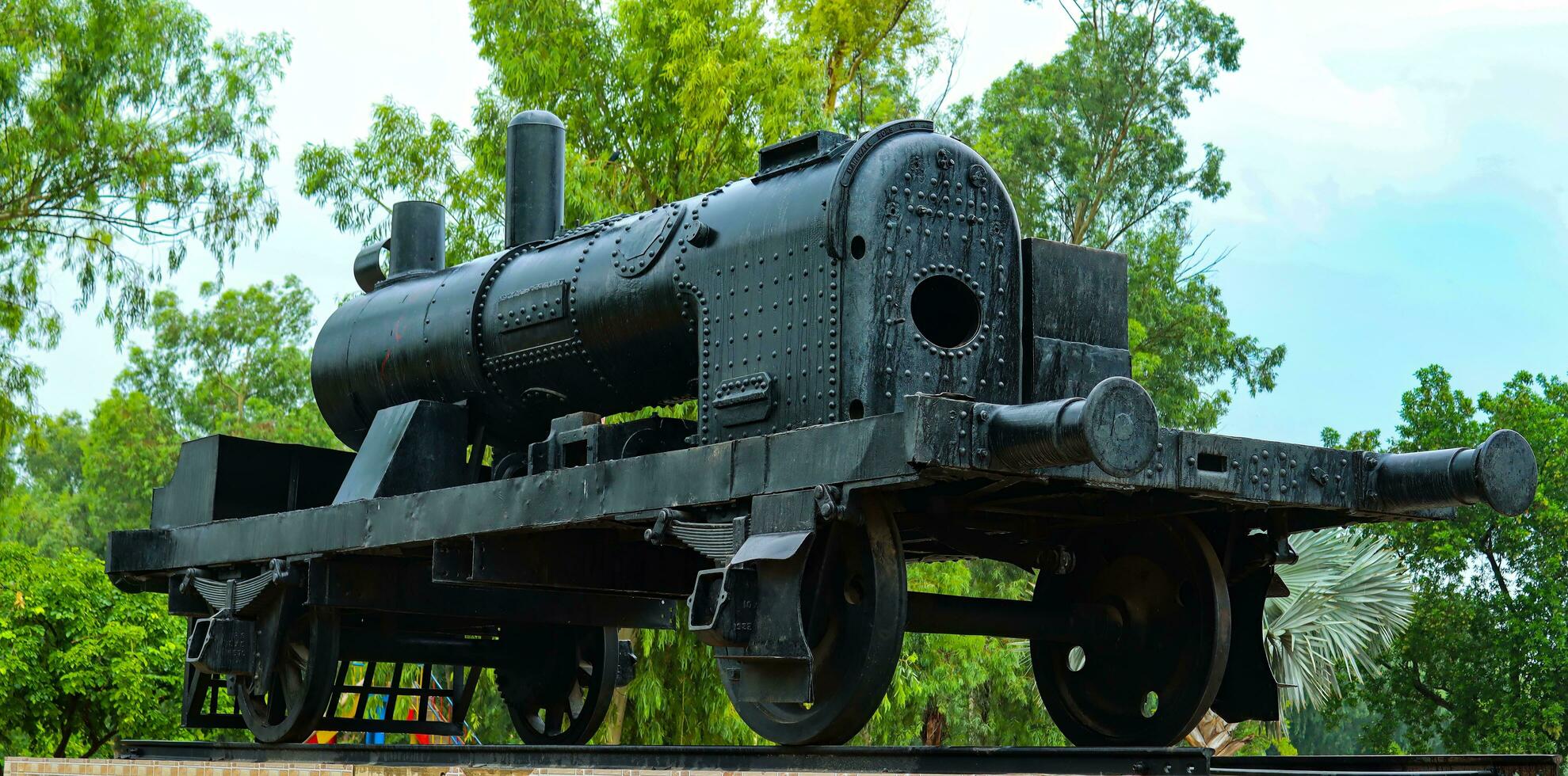 Photo of black steam locomotive,steam train, a piece of best old technology,Old retro locomotive on a pedestal,old steam polish rail engine in park