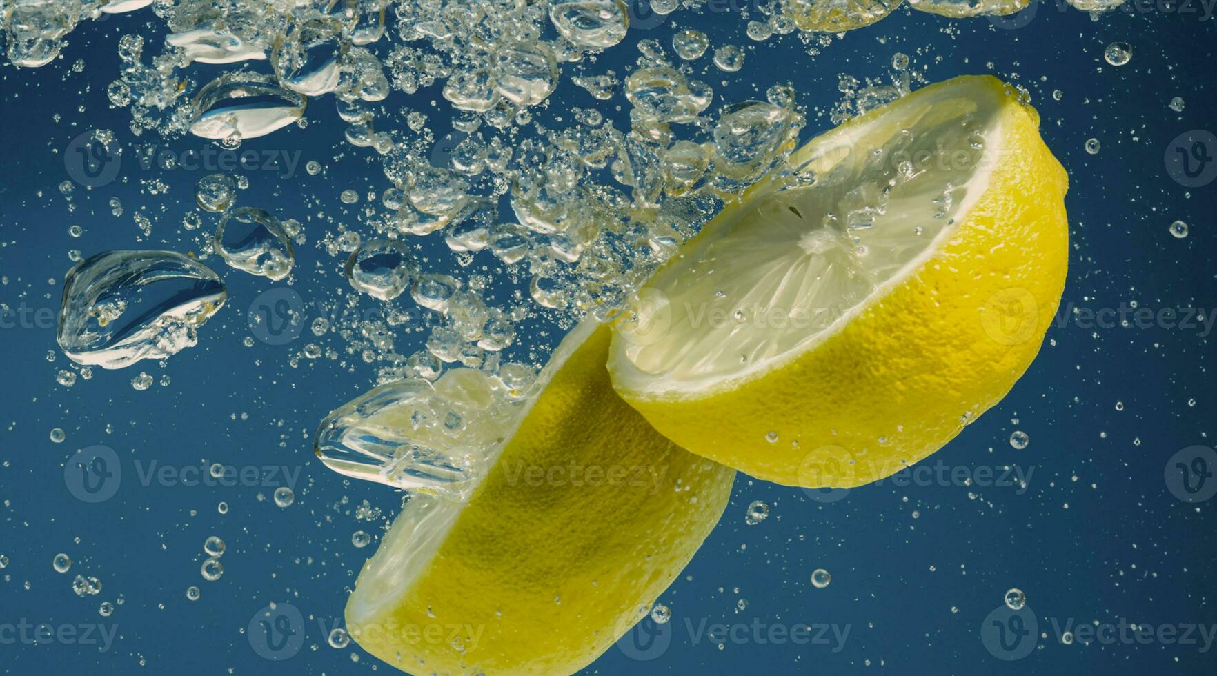 Underwater lemon slice in soda water or lemonade with bubbles. photo